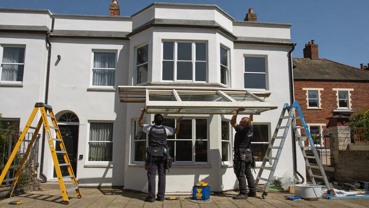 Two installers fitting a large bay window to a bay-fronted home