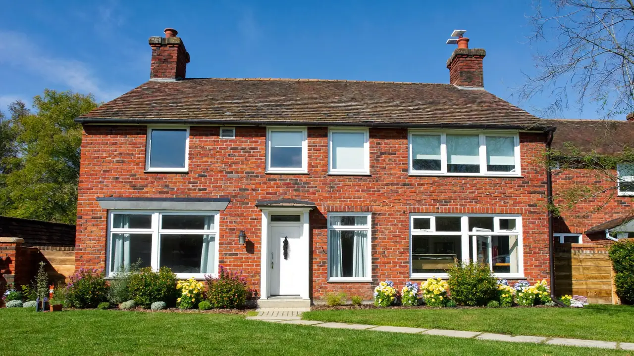 New double-glazed windows fitted across the front of a red-brick house